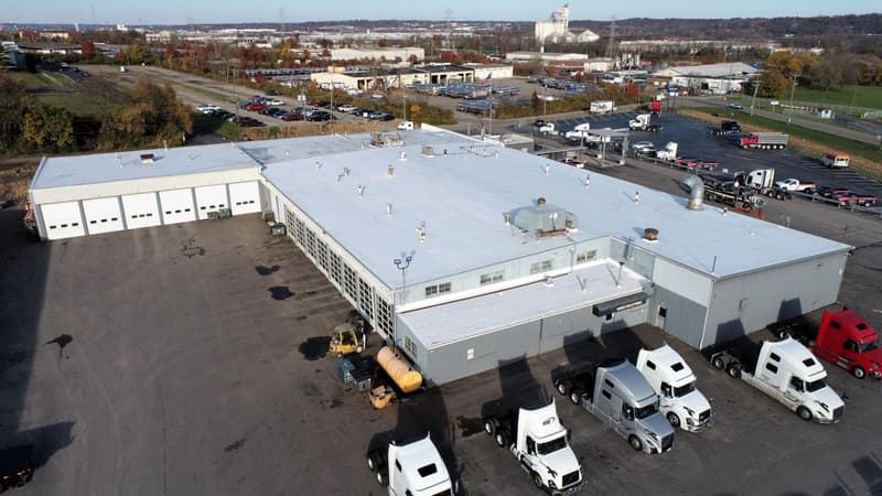 Aerial view of large commercial roof with semi trucks parked