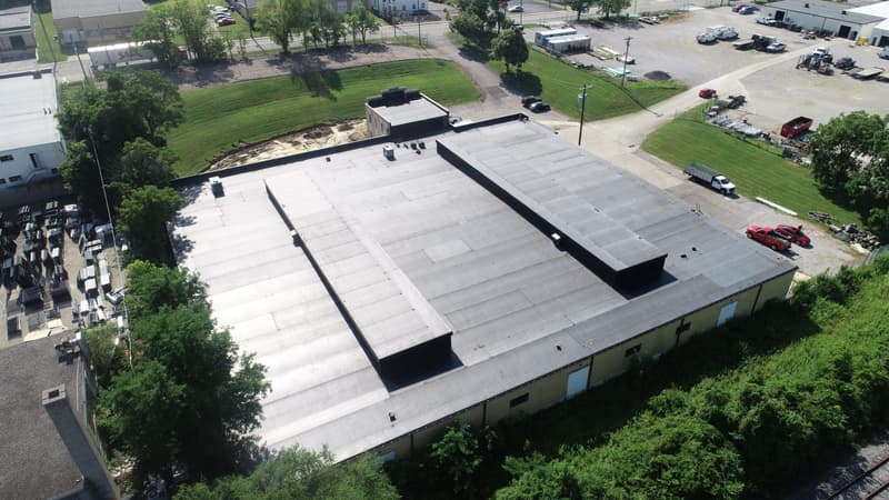 Aerial view of flat roof on commercial building with parking