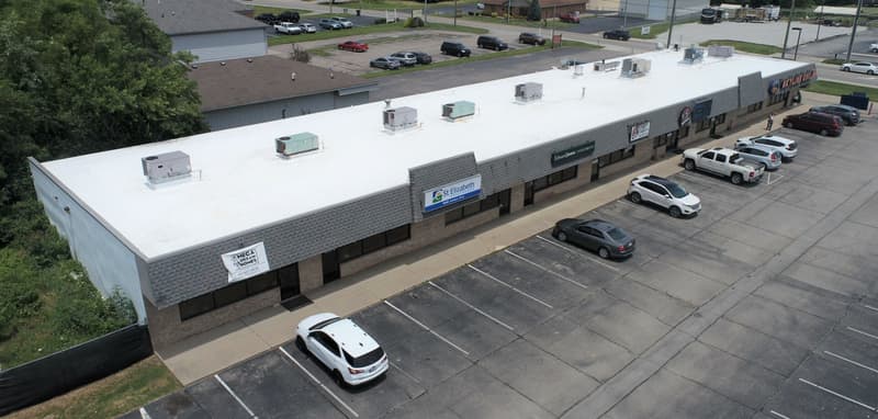 Aerial view of flat white roof on strip commercial building